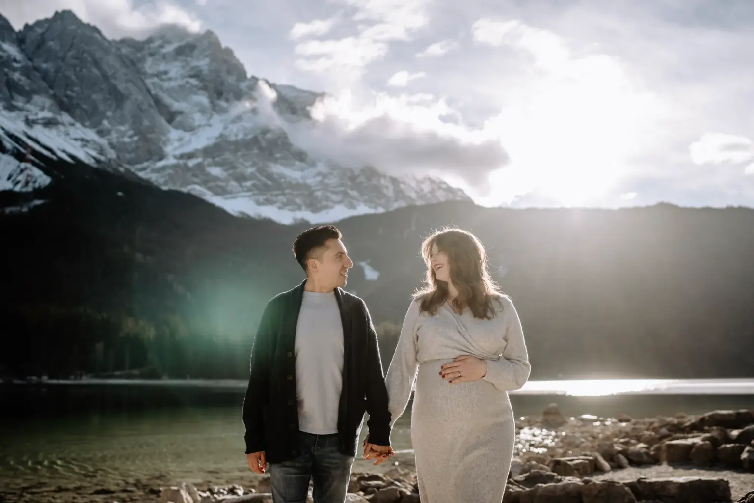 Paar läuft Hand in Hand am Eibsee mit der Zugspitze im Hintergrund