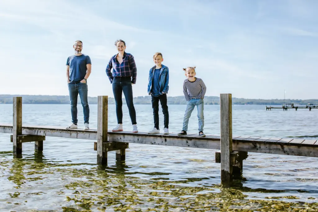 Familie steht auf dem Steg im Starnberger See