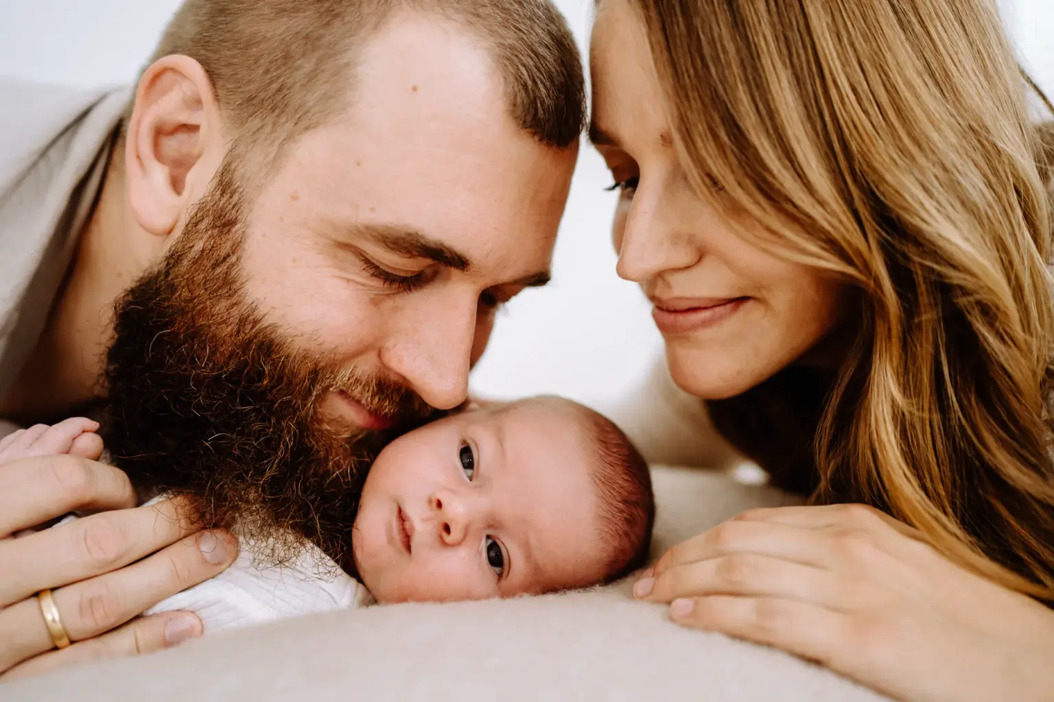 Mama und Papa schauen ihr waches Baby an und genießen den Moment