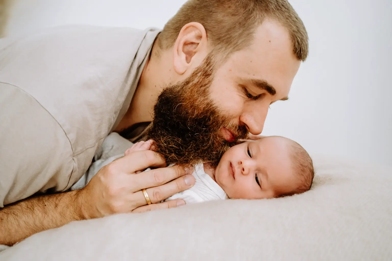 Papa gibt seinem Baby liebevoll einen Kuss auf die Wange