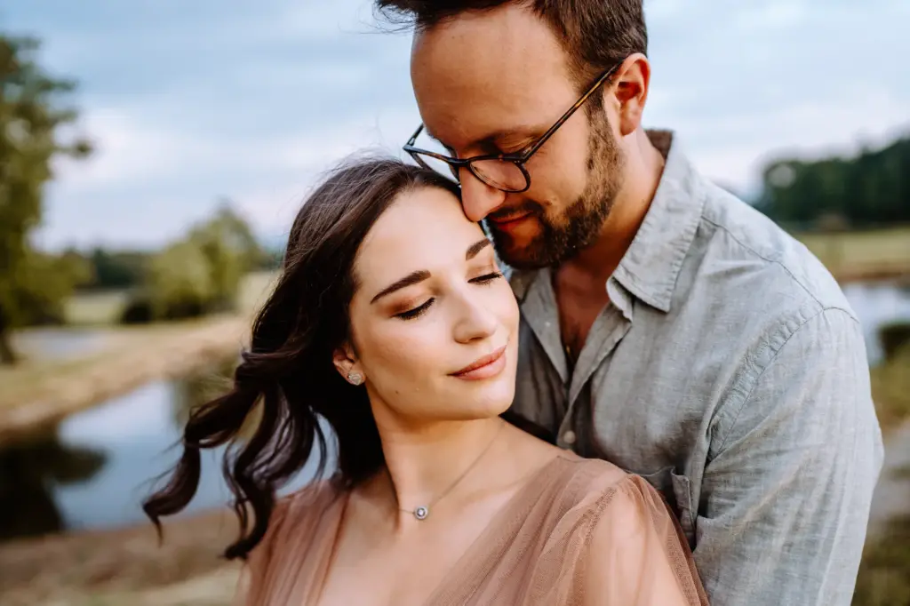 Paar schaut sich an und lächelt, authentische Babybauchfotos am Starnberger See