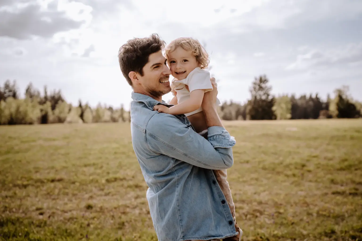 Papa kuschelt mit einem Kind auf dem Arm