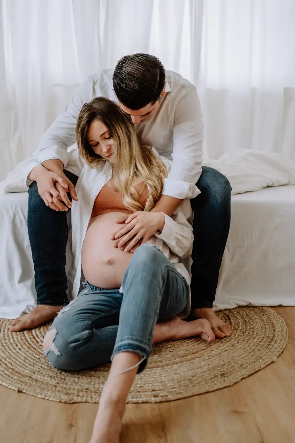 Schwangere sitzt entspannt, Babybauchshooting im Studio, clean und modern