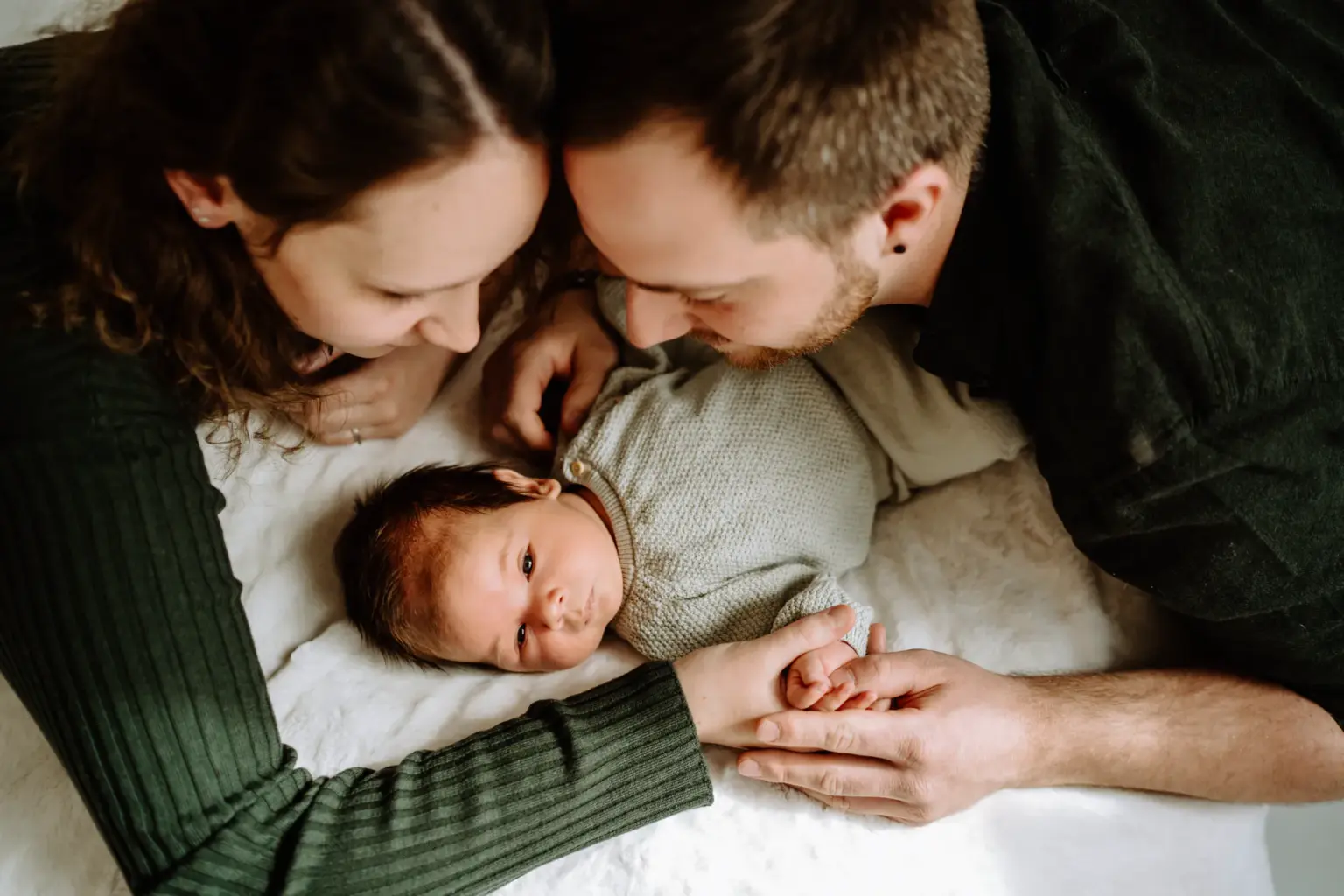 Eltern schauen ihr Baby liebevoll an, echte Emotion, Studio Weilheim