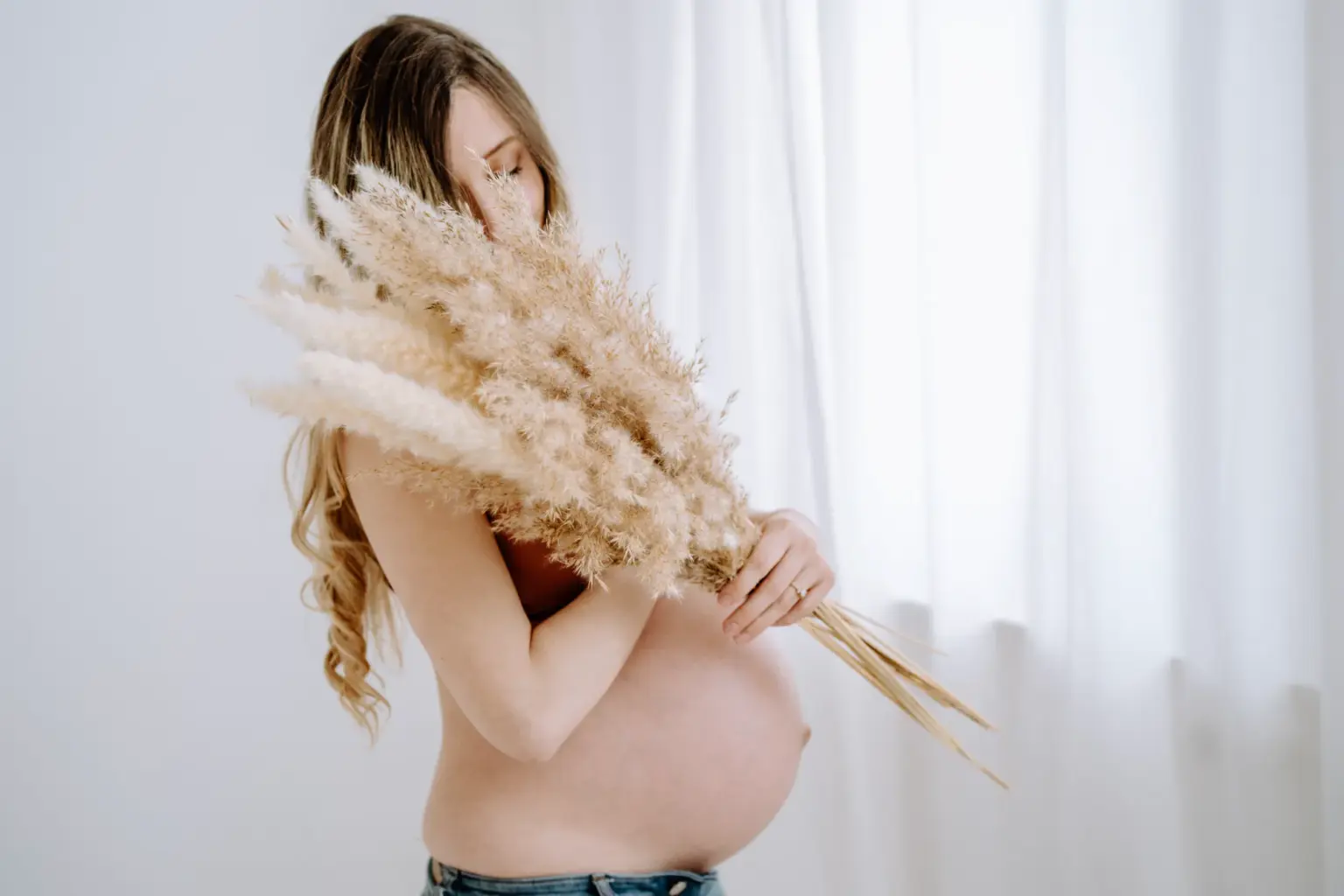 Babybauchfotos mit Trockenblumen als besonderes Accessoire