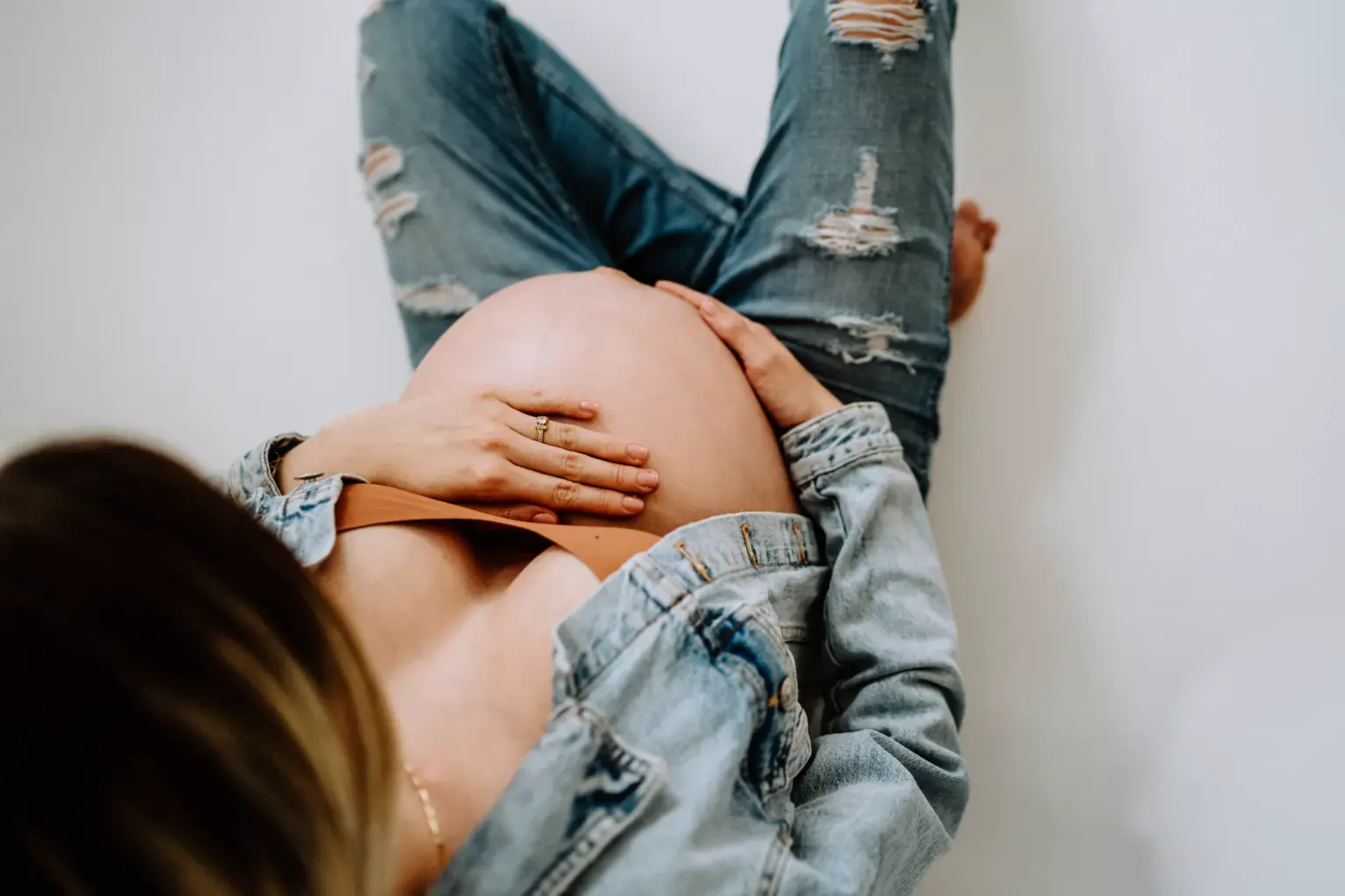 Schwangere in schlichtem Outfit, minimalistisches Babybauchfoto im Studio