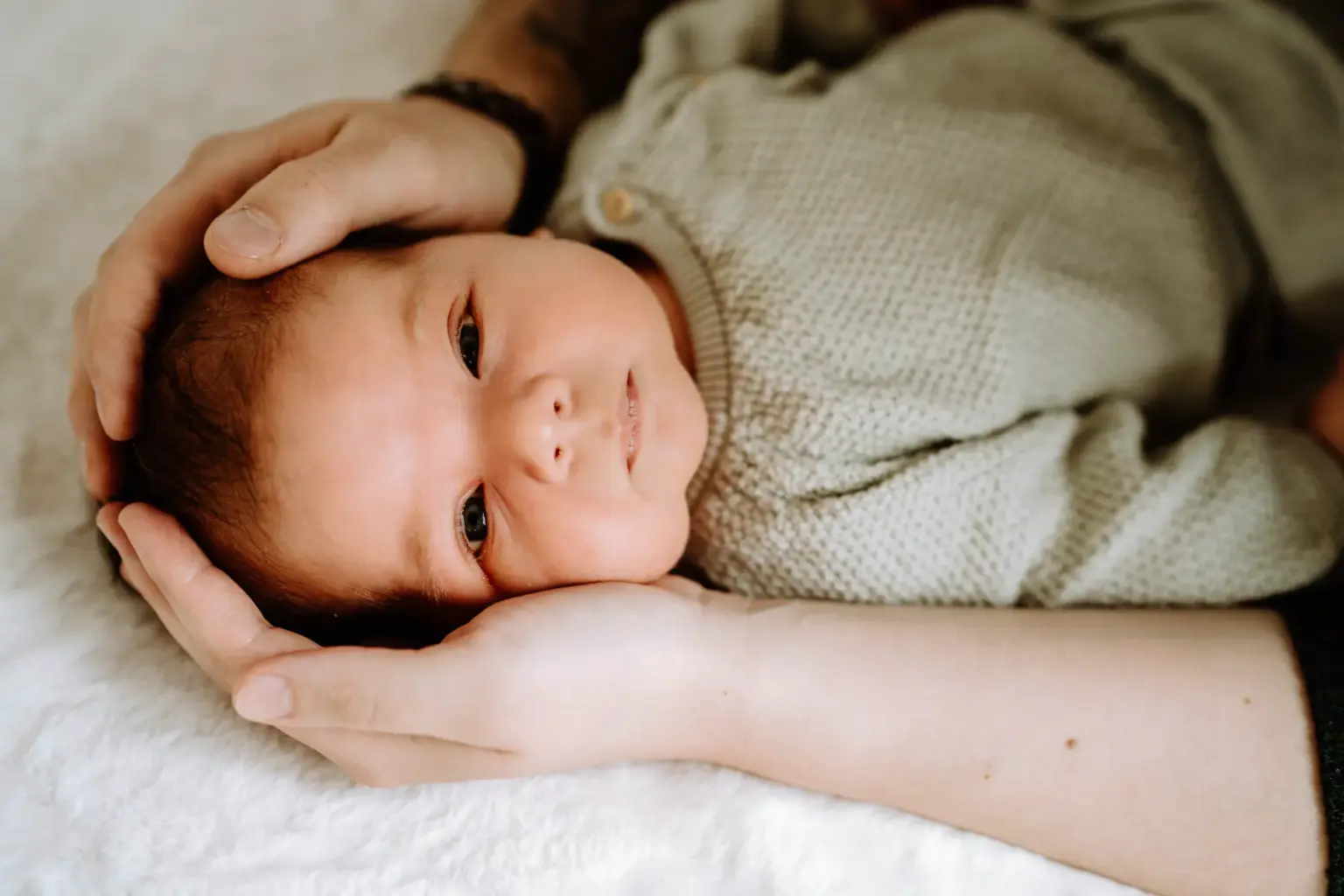 Hände der Eltern umschließen Baby, Geborgenheit, Newbornfoto Weilheim