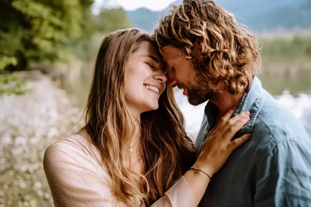 Paar lacht im Wasser, spontane Szene, Babybauchshooting am Kochelsee