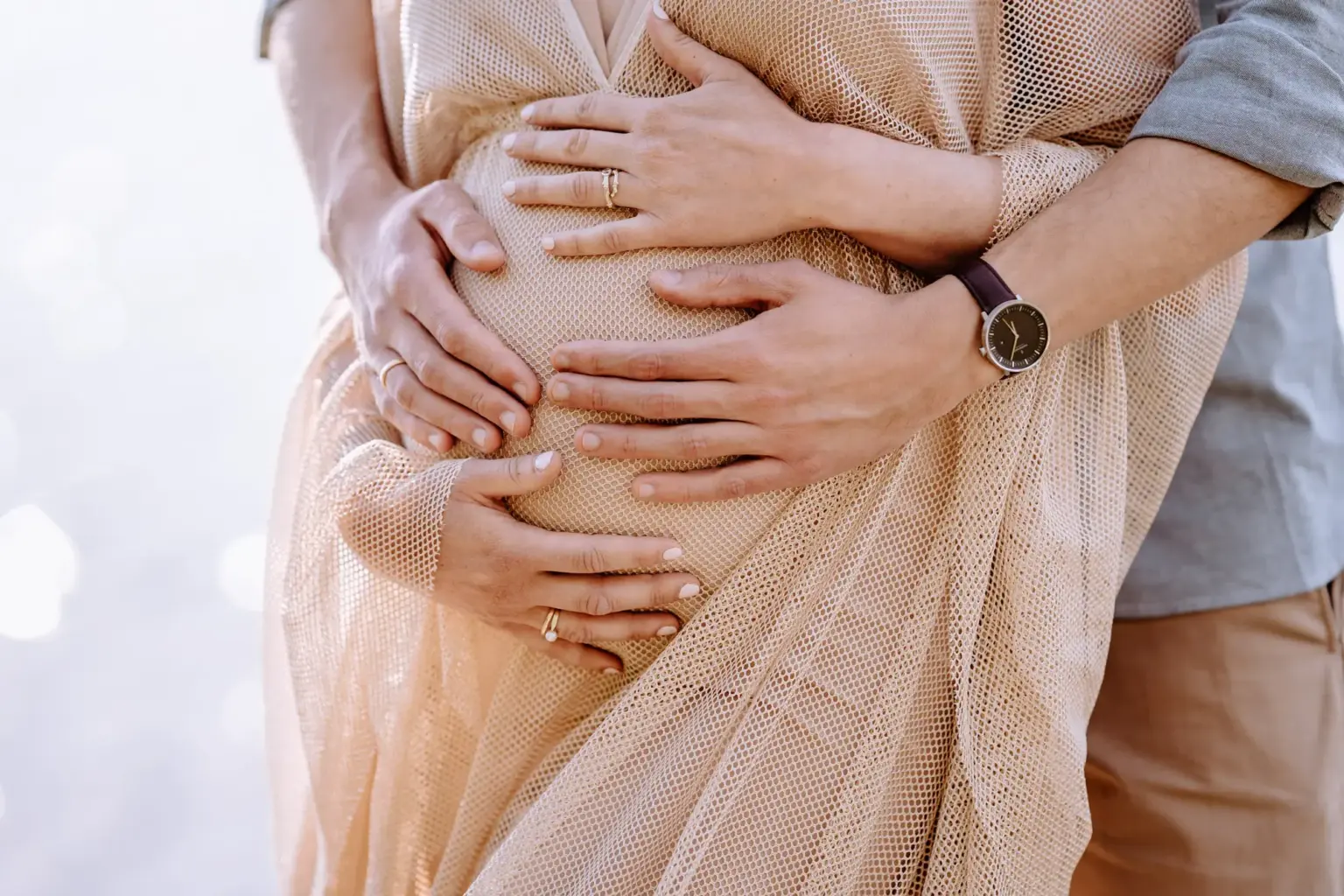 Babybauch Portrait mit Gegenlicht, weiches Licht über dem Wasser
