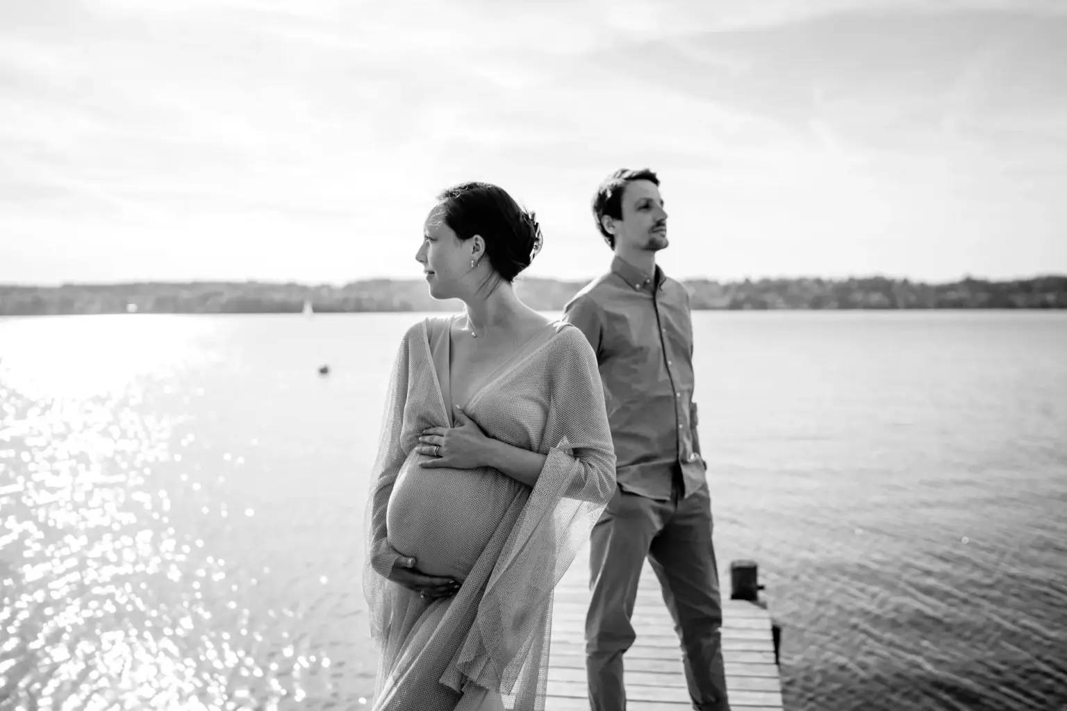 Paar steht seitlich am Steg, Babybauch sichtbar, ruhige Stimmung