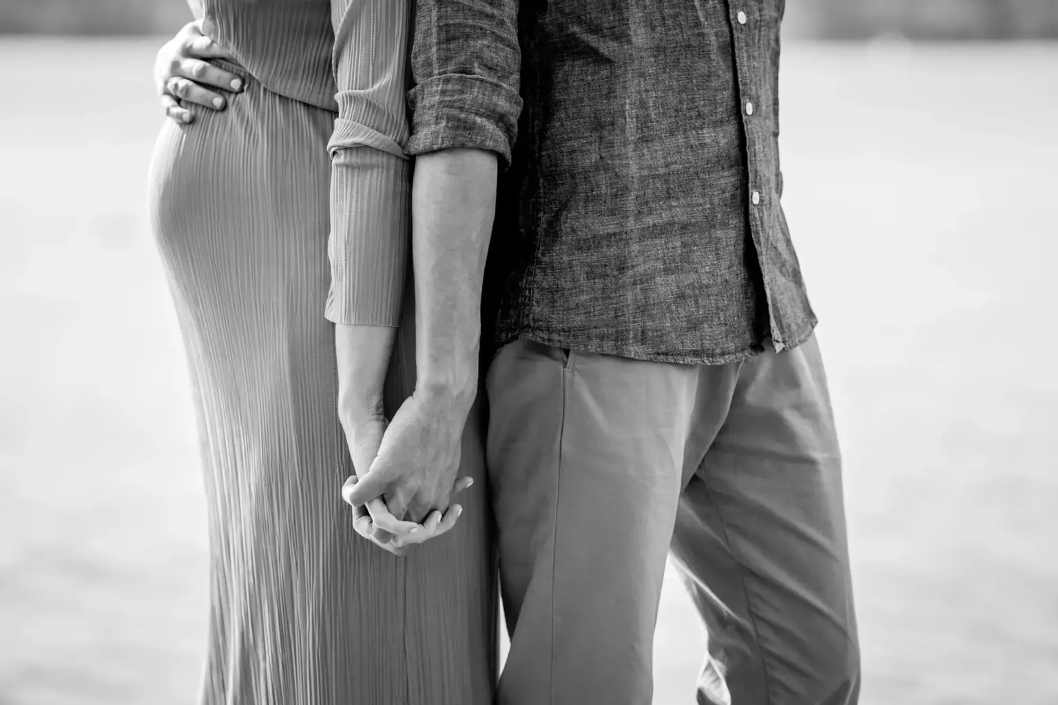 Paar geht Hand in Hand vom Steg zurück, Babybauch Shooting