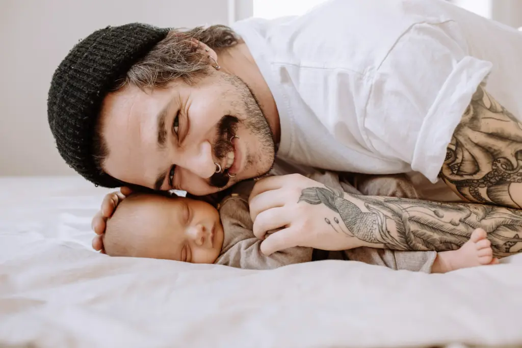 Inniges Foto von Papa und dem Baby auf dem Bett