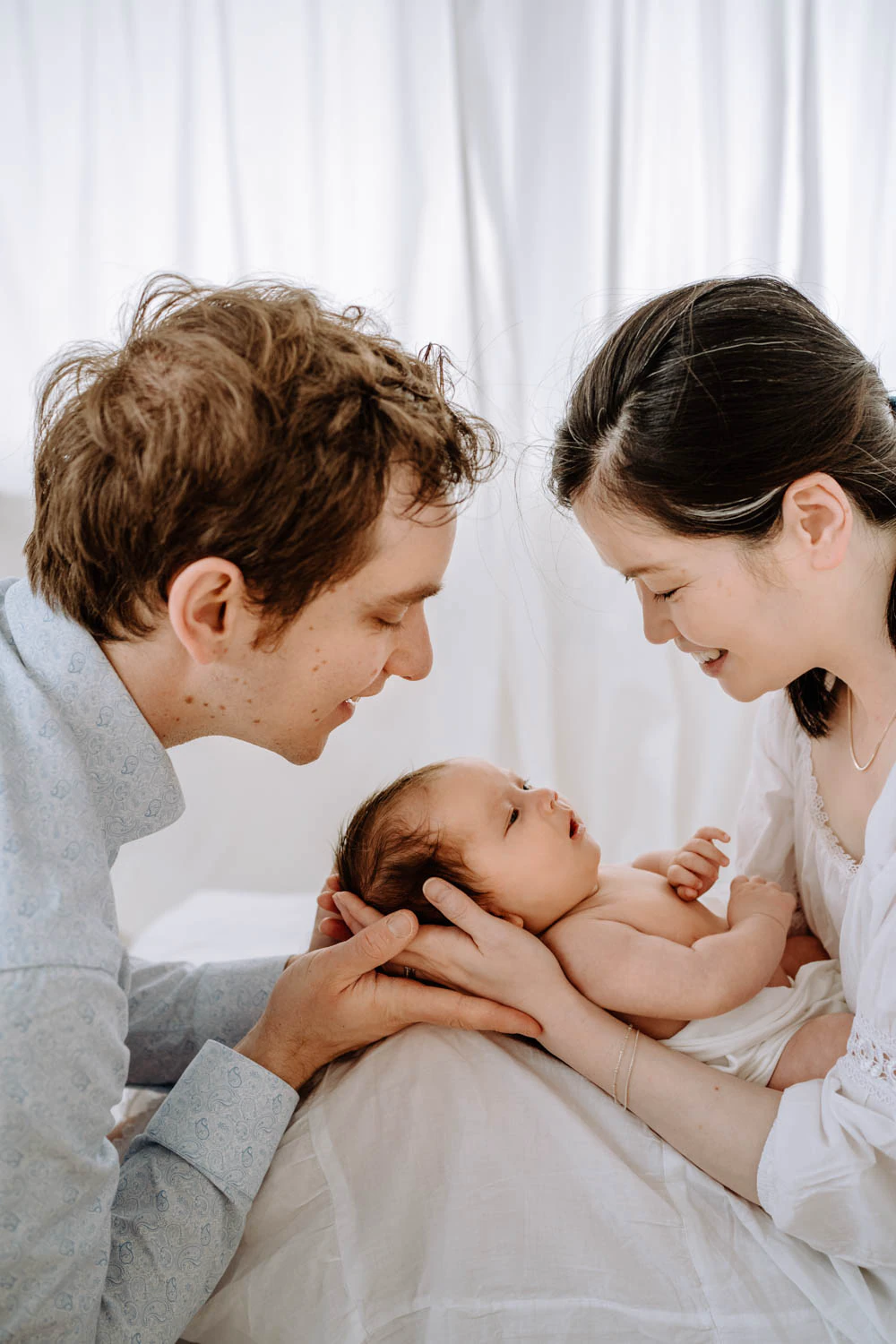 Familie zu dritt vor weißem Hintergrund, minimalistische Babyfotos