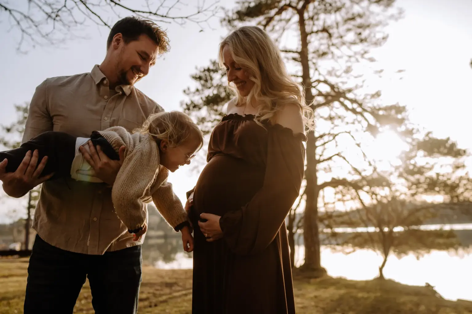 kleine Kinderhand auf Babybauch, Familienmoment in der Natur